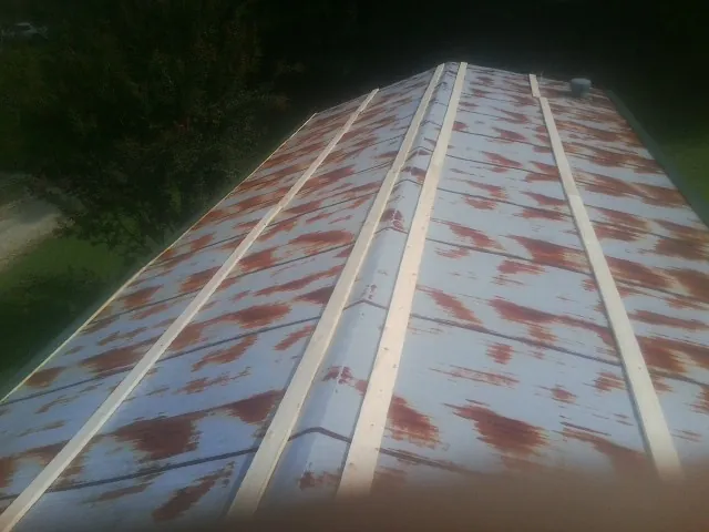 Rusted metal roof panels with new wood purlins before replacement — Storm Damage Roof Repair in Woodcliff Lake by Roofing Brothers