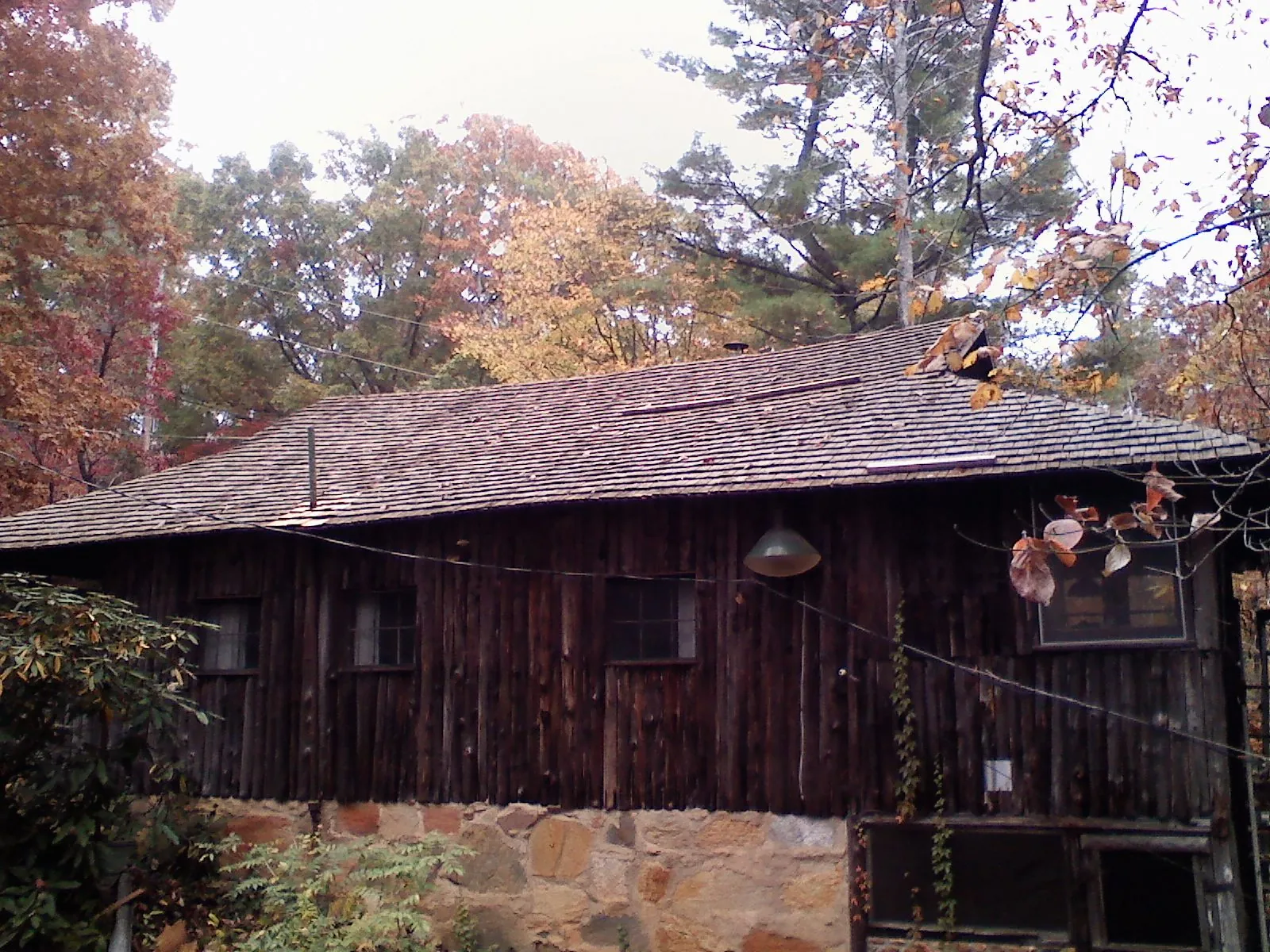 Weathered wood shake roof on a rustic board sided cabin in Woodcliff Lake