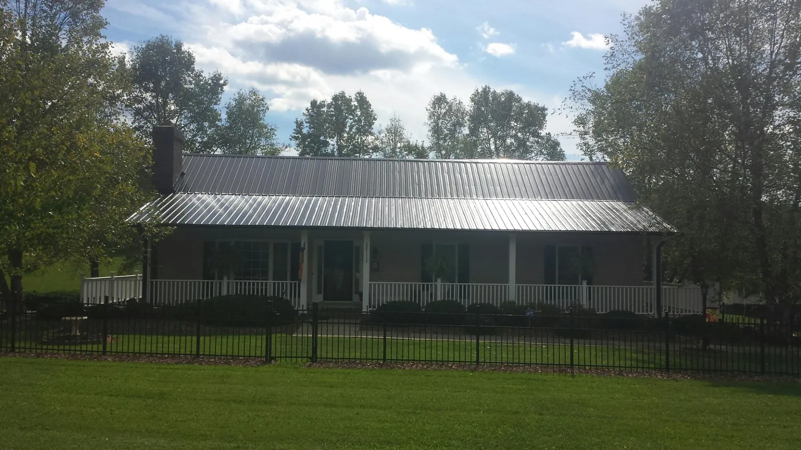 Gray metal roof on a brick ranch with a full width front porch — Gutter Guard Installation work by our crew in Woodcliff Lake