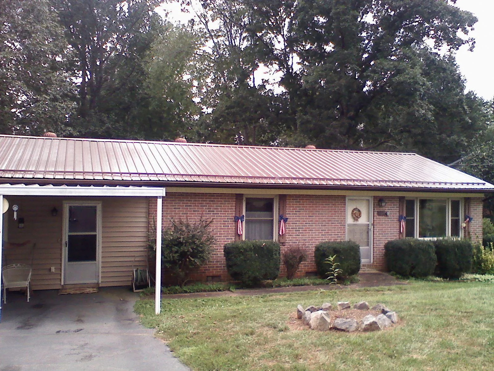 Bronze metal roof and carport on a brick ranch home — Roof Repair work by our crew in Woodcliff Lake